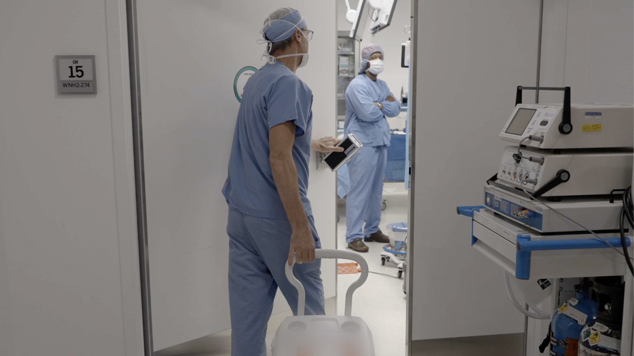 Cleveland Clinic caregiver walking a transplant cooler into surgery.