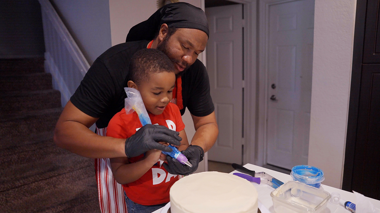 Tremaine baking a cake with family