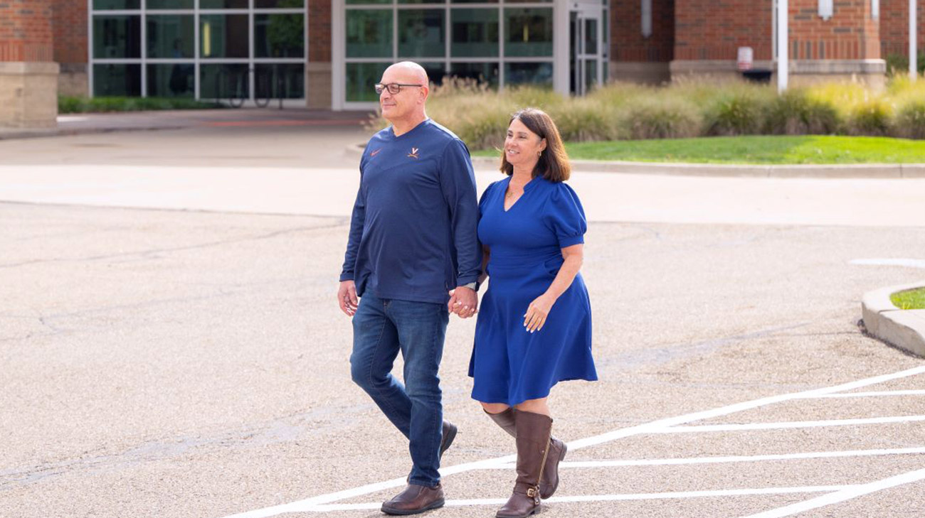 Cathy walking with her husband in the parking lot of Akron General.