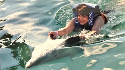 Evelyn Greenberger swimming with a dolphin.