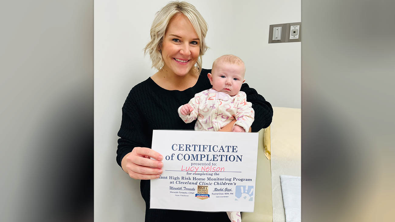Lucy and her mom, Jaclyn, receiving a certificate of completion from the Cleveland Clinic Children's Infant High-Risk Program.