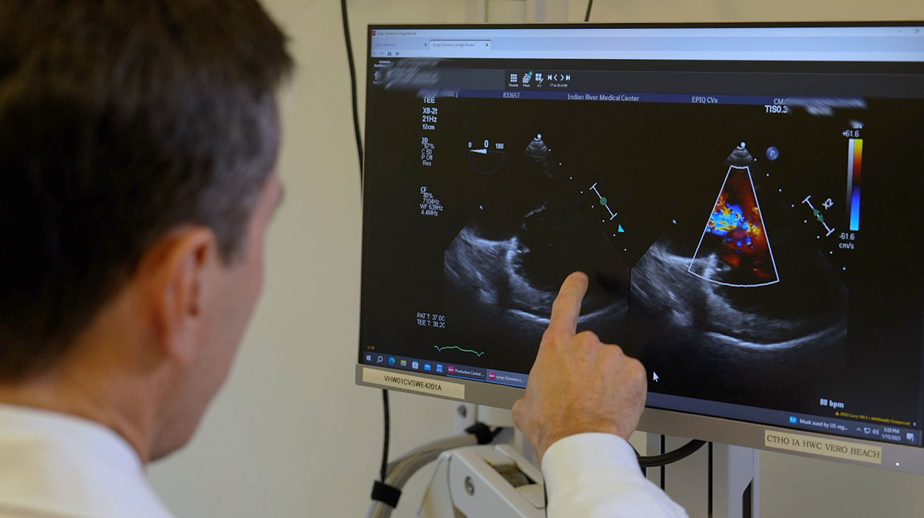 Dr. James Wudel looking at a diagnostic scan of a heart.