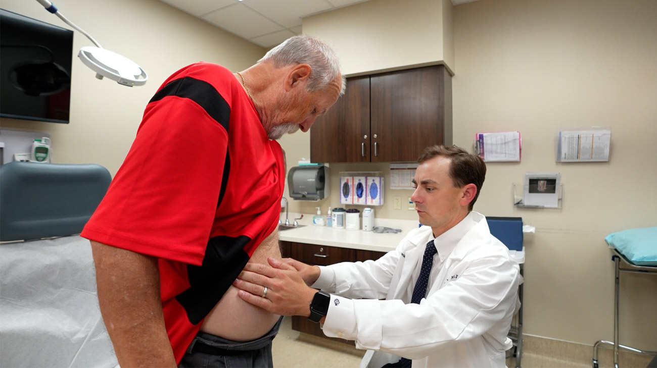 John Holcomb having his abdomen checked by Eric Owings, MD at Cleveland Clinic.