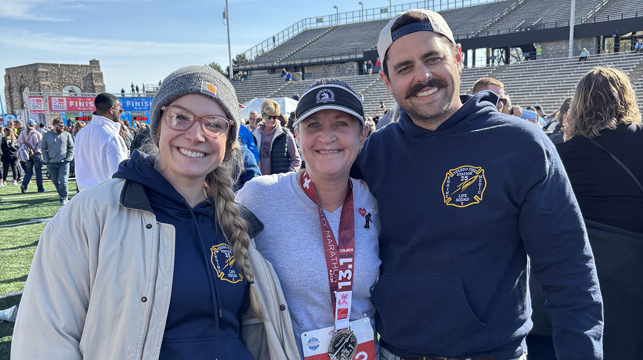 Nancy with the paramedics who saved her at the Glass City half marathon in 2024. 