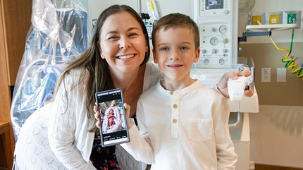 Nathan Jensen with his mom showing a picture of himself as a baby.