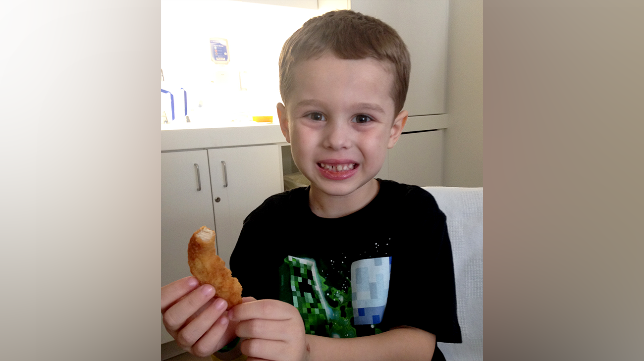 Jacob eating chicken tenders after he was allowed to eat solid food again