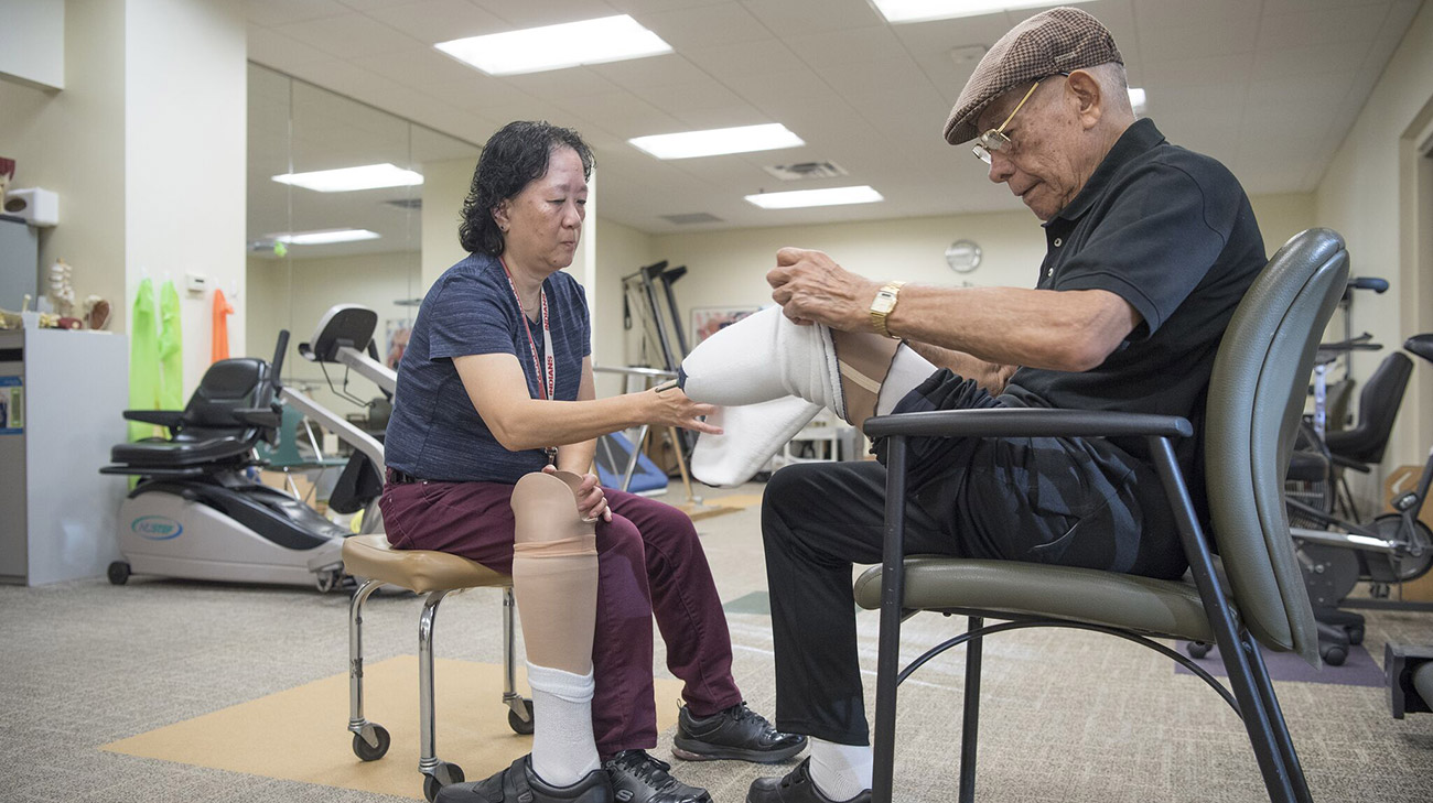 Physical Therapy Assistant Mary Yee checks on Angel’s leg.