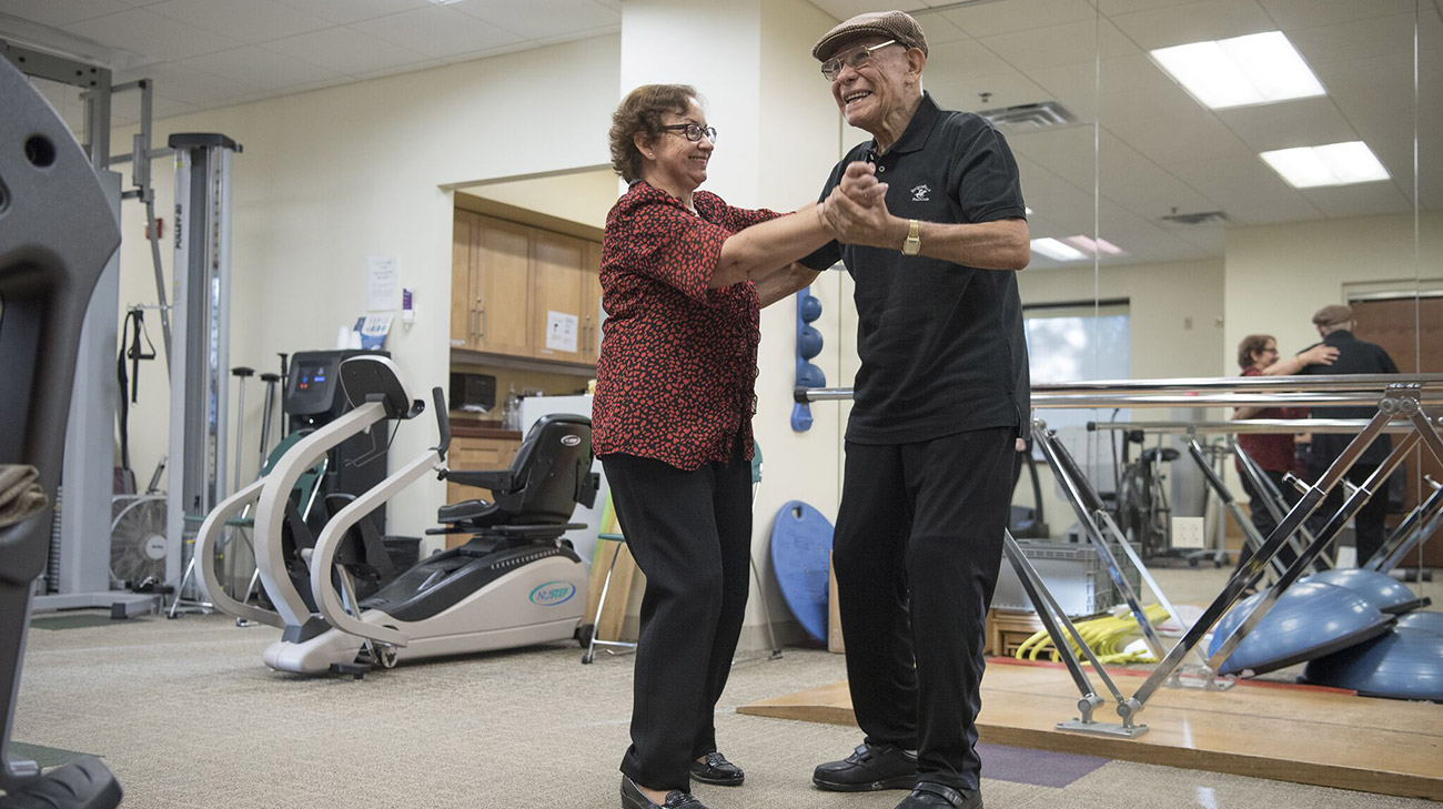 Angel and his wife, Raquel, dance at a physical therapy appointment.
