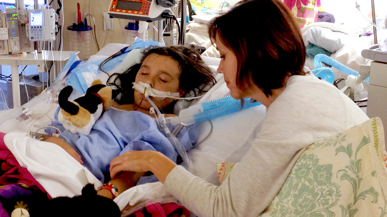 Sophia’s mom, Carole, comforting Sophia while she’s on ECMO