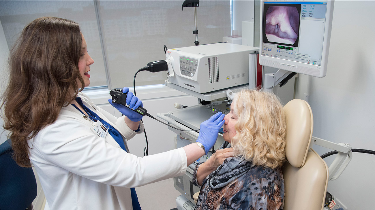 Speech and voice pathologist Michelle Adessa places a scope to examine Christine’s vocal cords.