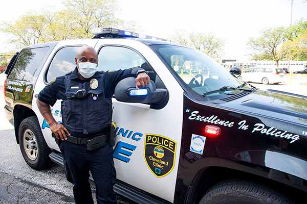 Police Officer in mask standing in front of his vehicle