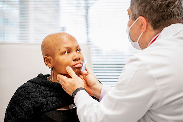 Caregiver examining young patient's lymph nodes.