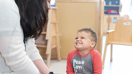 Little boy smiling up at healthcare provider.