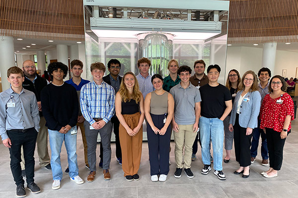 Group of students pictured in front of Cleveland Clinic's IBM Quantum System One.