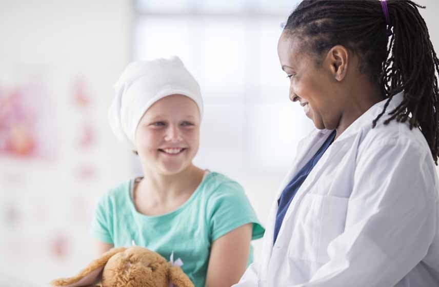 Female doctor smiling while examining pediatric patient.