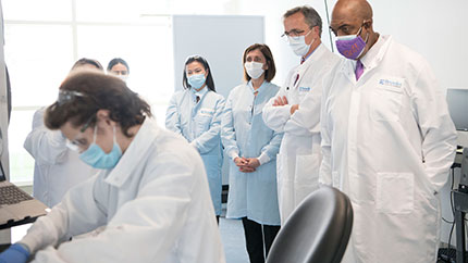 Cleveland Clinic leaders watching a researcher